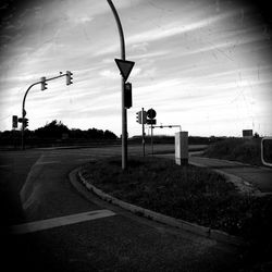 Cars on road against cloudy sky