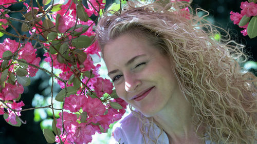 Close-up portrait of young woman with red flowers