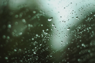 Melancholic full frame shot of raindrops on glass window 