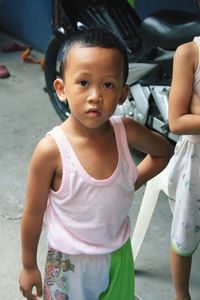 Portrait of boy with hand on hip standing outdoors