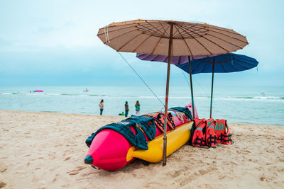 Deck chairs on beach against sky