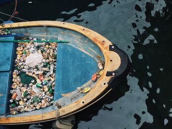 High angle view of drink cans in boat at harbor