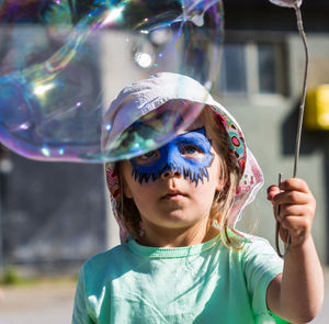 Close-up of girl looking at bubble