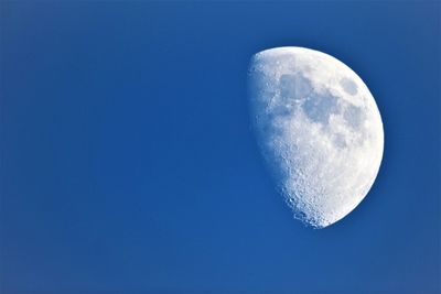 Low angle view of moon against blue sky