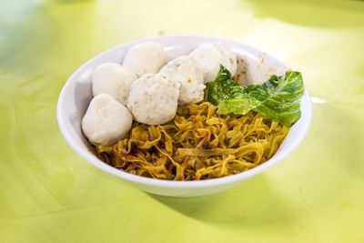 Close-up of fish balls and meatballs with noodles in bowl