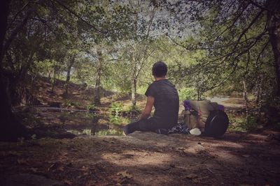 Rear view of man sitting in forest