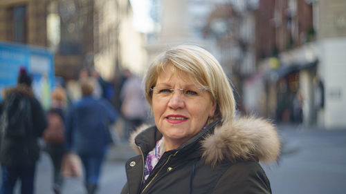 Portrait of senior woman wearing jacket on street in city