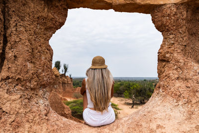Rear view of woman standing in cave