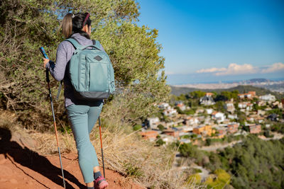 Woman contemplates the landscapes of the garraf natural park while walking the paths of a mountain.