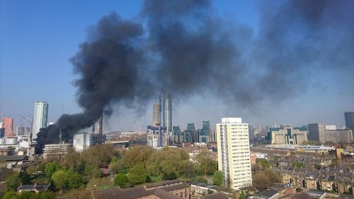 Smoke emitting from factory against sky