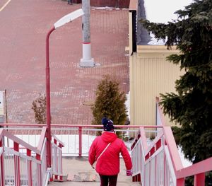 Rear view of people walking on staircase against building