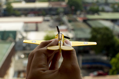 Close-up of hand holding toy airplane