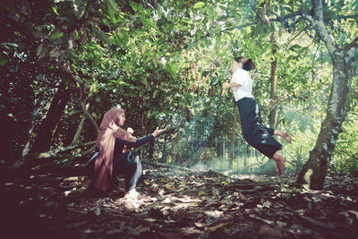 Side view of young woman in forest