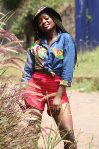 Portrait of smiling young woman standing on land