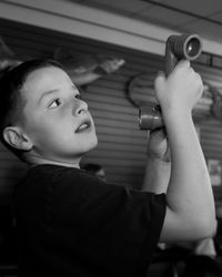 Boy holding periscope in classroom