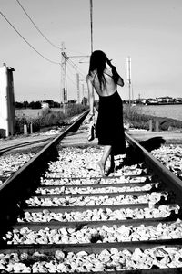 Man on railroad tracks against clear sky