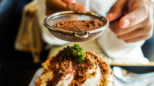 Close-up of hand making dessert