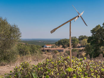 Wind turbines on field against sky