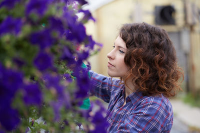 Close-up of woman by purple flowering plants