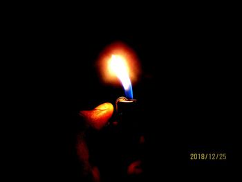 Close-up of burning candle in darkroom