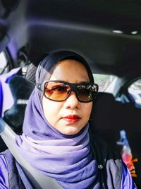 Portrait of young woman wearing sunglasses in car