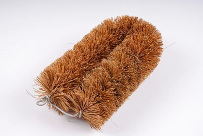 Close-up of brown toilet brush on white background