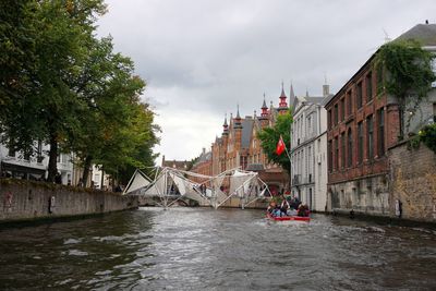 River amidst buildings in city against sky