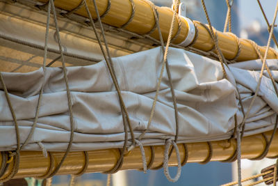 Close-up of canvas tied in rope on boat