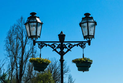 Low angle view of street light against blue sky