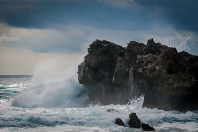 Scenic view of rocks in sea against sky