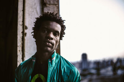 Portrait of young man standing against sky