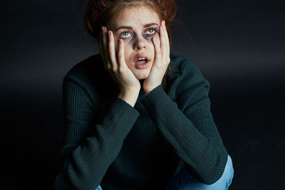 Young woman with bruise on face against background