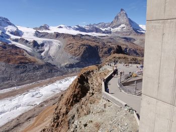 People at observation point with mountains against sky during winter