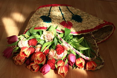 Flowers in basket on wooden table