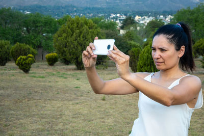 Side view of young woman using mobile phone