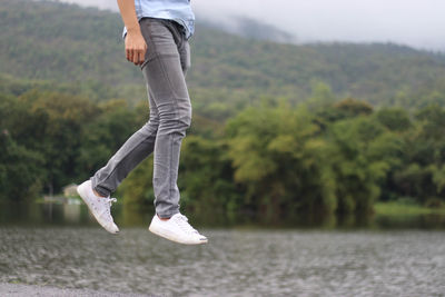 Low section of man on cliff against mountain