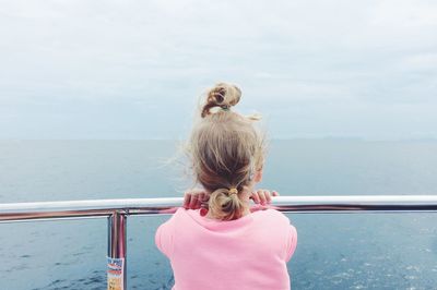 Rear view of girl against sea against sky