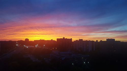 Silhouette cityscape against sky during sunset