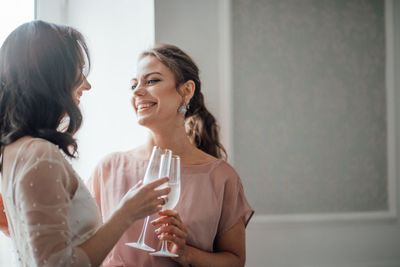 Happy young woman drinking water from glass