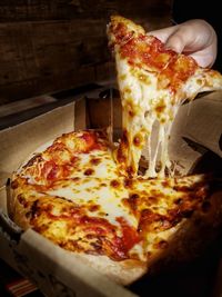 Close-up of hand holding pizza