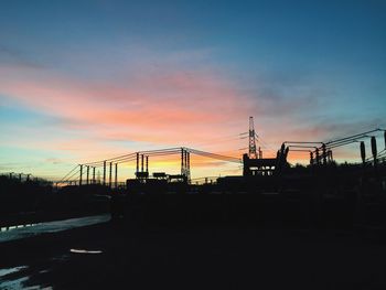 Silhouette cranes against sky at night