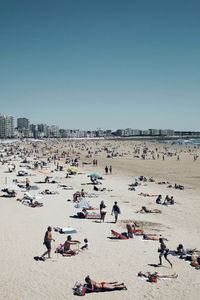 People on beach against clear sky