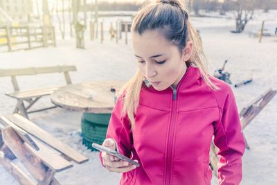 Young woman using phone while standing outdoors