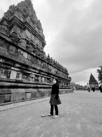 Rear view of woman walking on street against sky