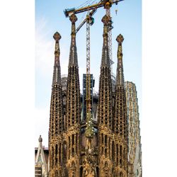 Low angle view of statue of buildings against sky