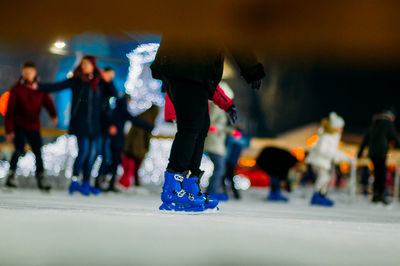 Low section of person skiing on ice rink