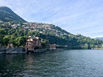 Scenic view of river by buildings against sky