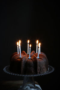 Close-up of illuminated candles in darkroom