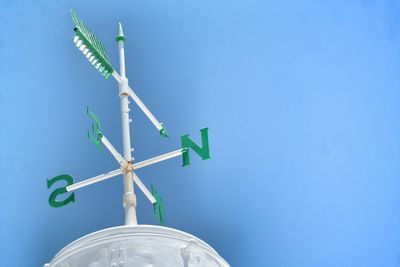 Low angle view of road sign against clear blue sky