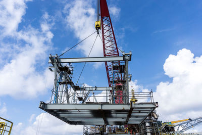 Offshore crane on board a construction work barge performing heavy lifting of a structure frame